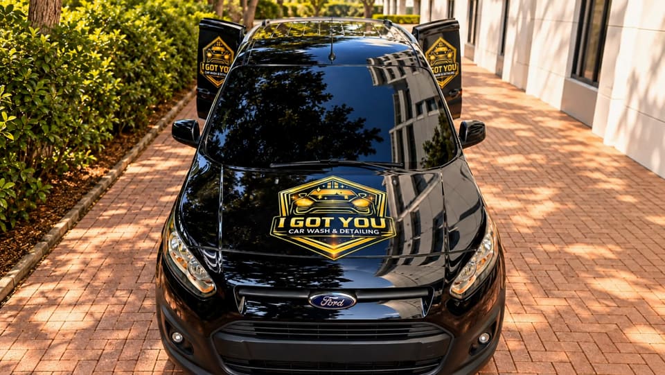 The I Got You branded black-and-yellow van parked on a brick driveway, front view.